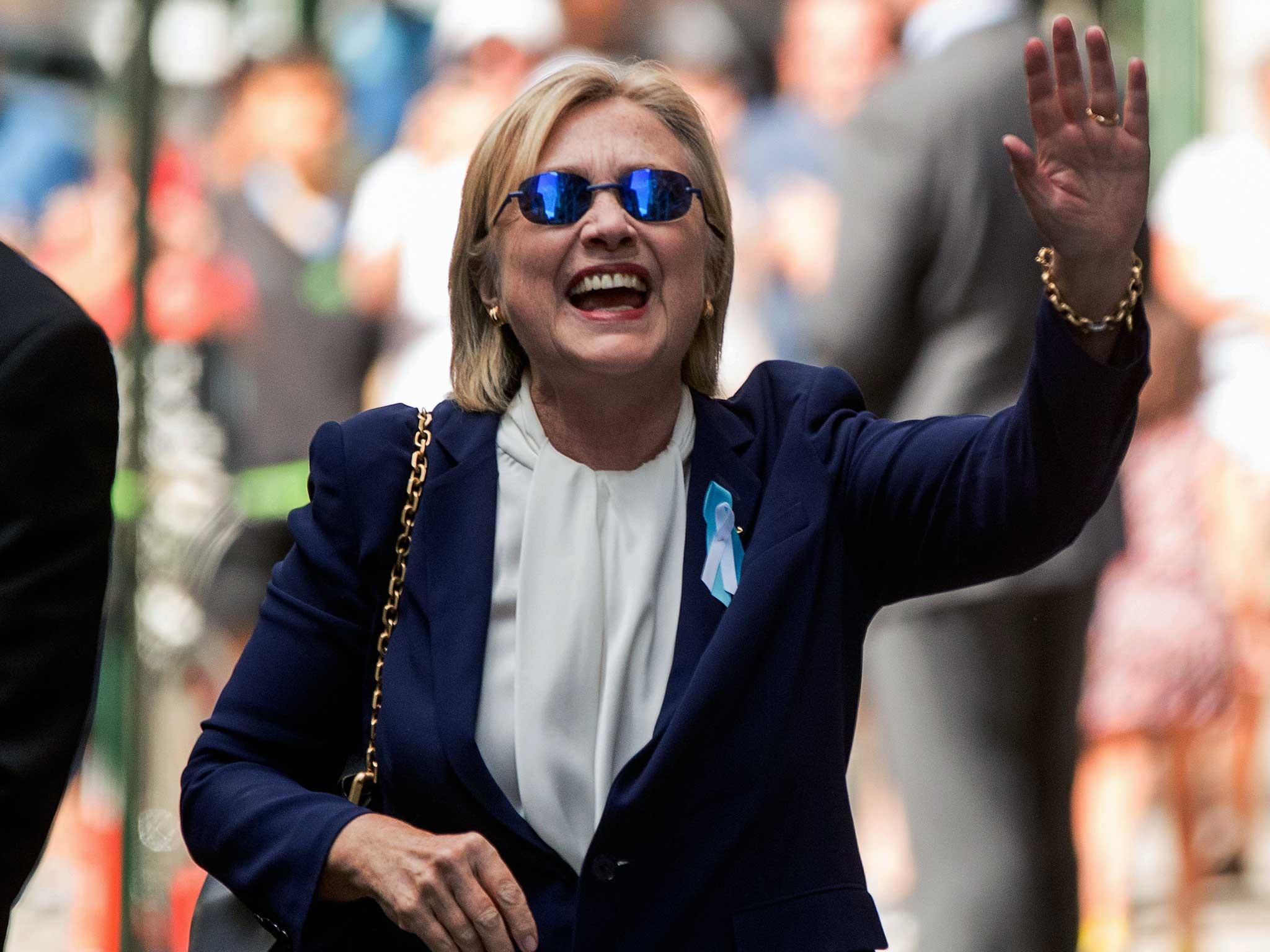 Hillary Clinton waves after leaving an apartment building in New York