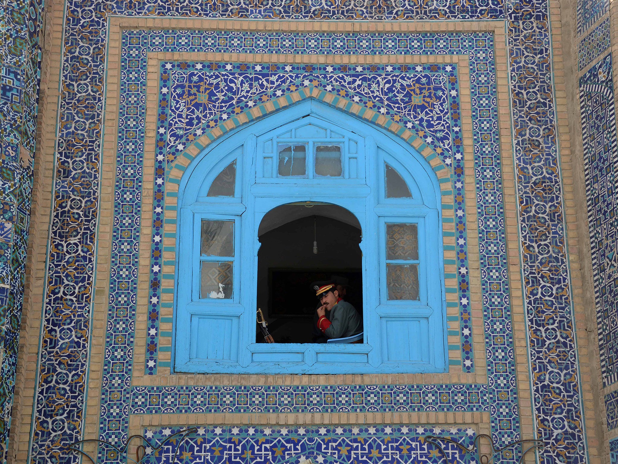 An Afghan guard of honour looks out as others offer Eid-al-Adha prayers at the Hazrat-i- Ali shrine in Mazar-i Sharif on September 12, 2016