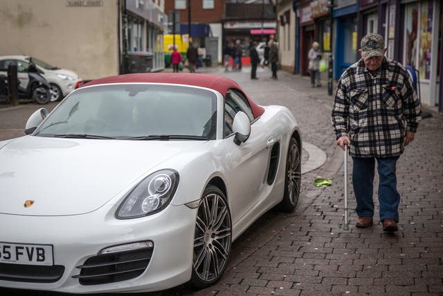A man walks past a Porsche in Aberdare, 2016. West Wales and the Valleys has been identified as the poorest region in the whole of north Western Europe