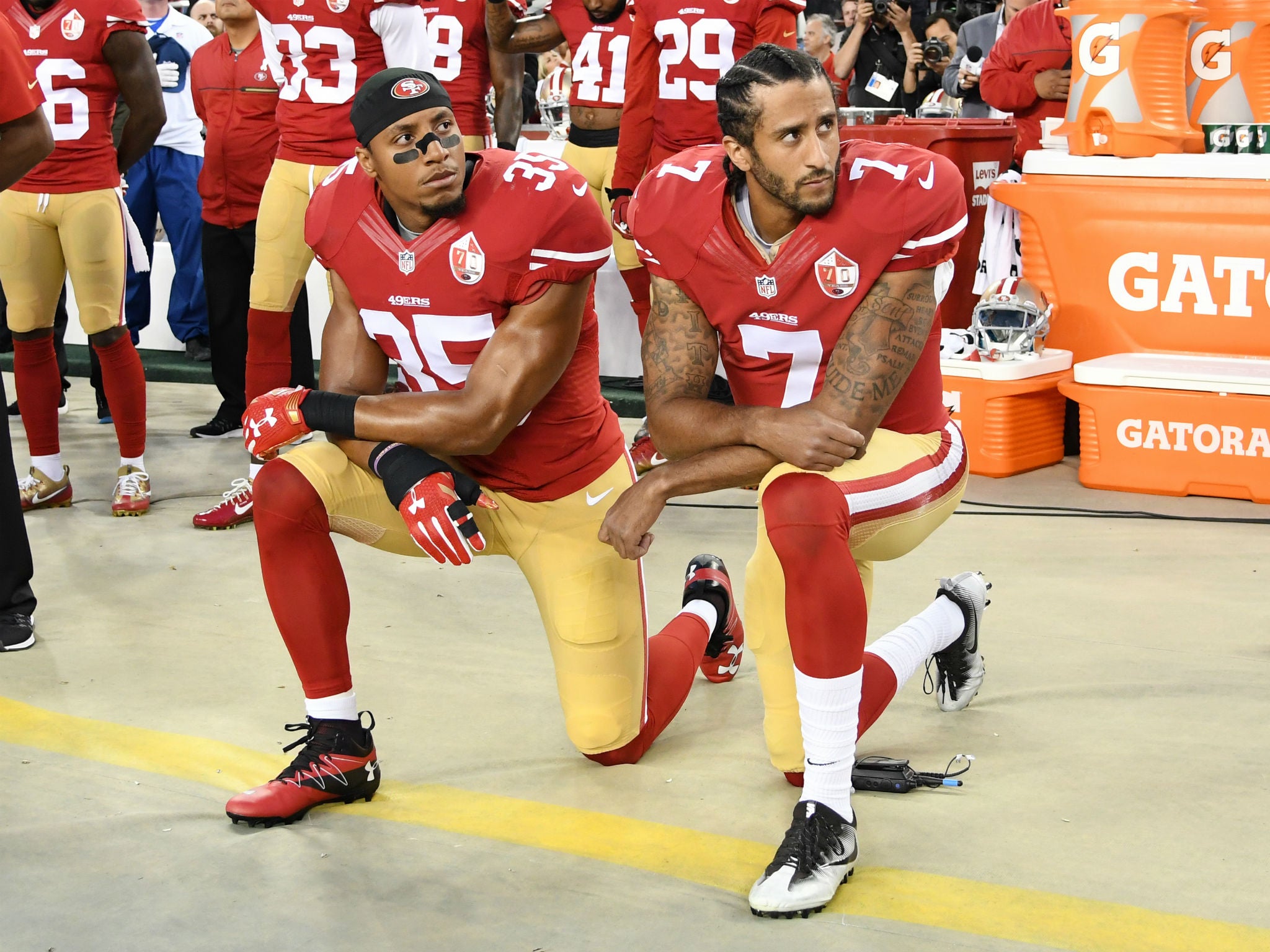 Colin Kaepernick #7 and Eric Reid #35 of the San Francisco 49ers kneel in protest during the national anthem prior to playing the Los Angeles Rams in their NFL game at Levi's Stadium on September 12