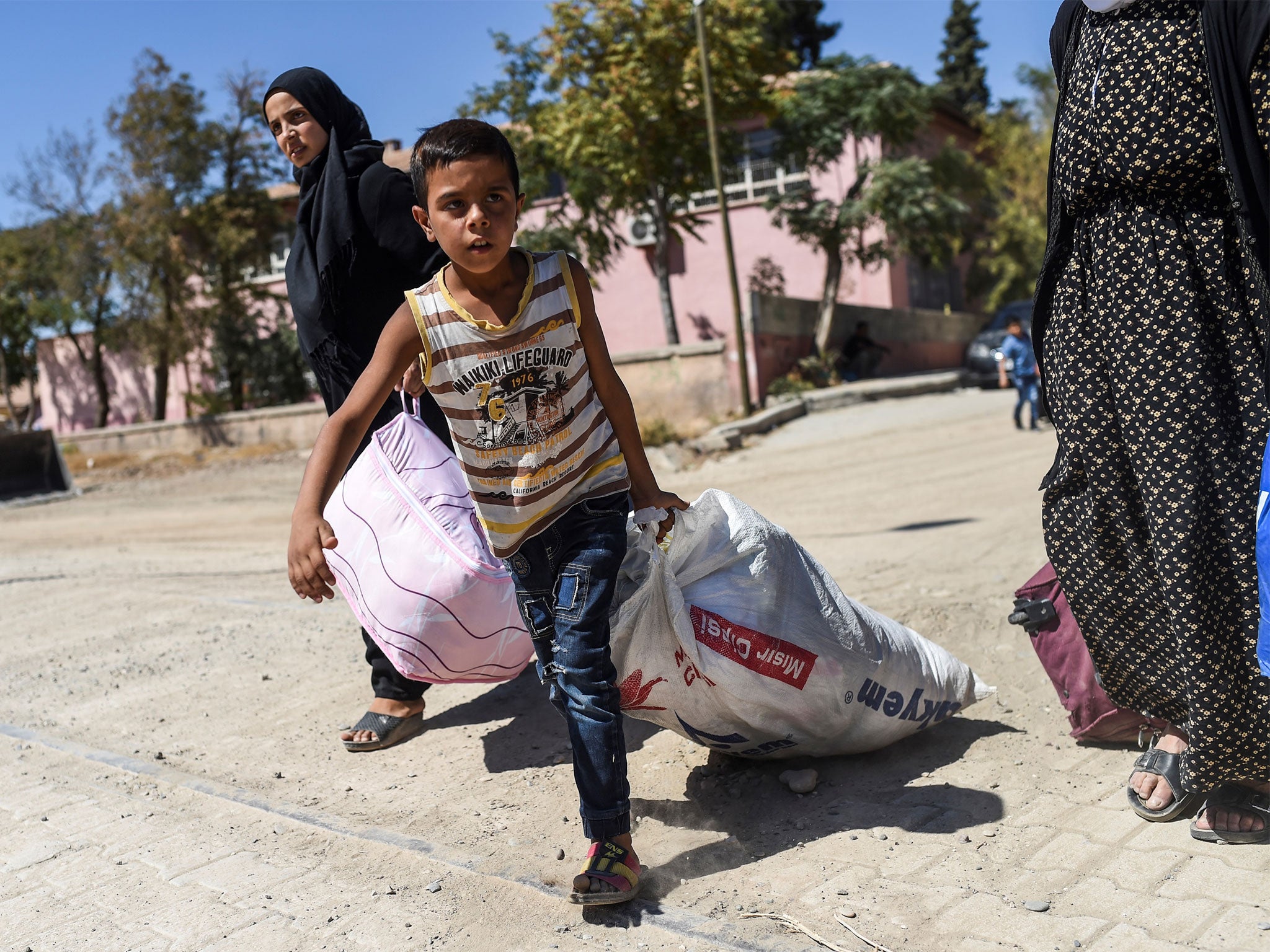 A refugee child walks back to the Syrian city of Jarabulus
