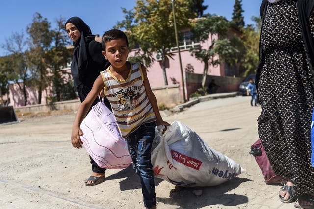 A refugee child walks back to the Syrian city of Jarabulus