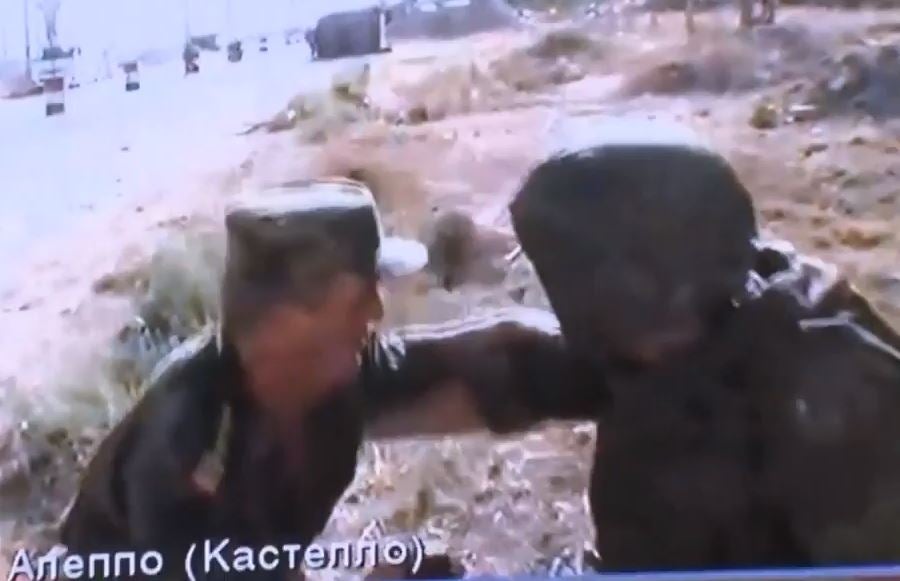 A Russian and Syrian soldier duck for cover amid gunfire during a live TV interview