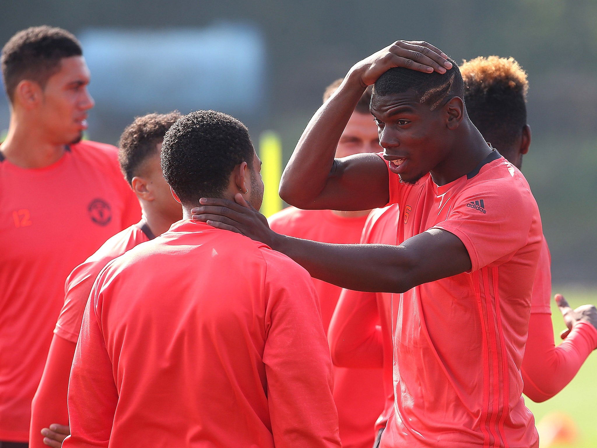 Paul Pogba reacts with Memphis Depay during Manchester United training