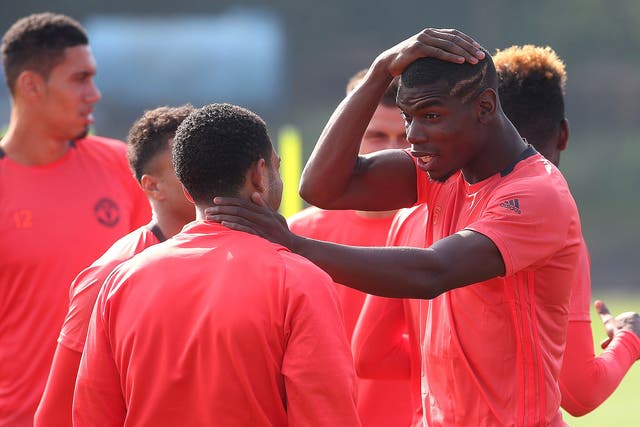 Paul Pogba reacts with Memphis Depay during Manchester United training
