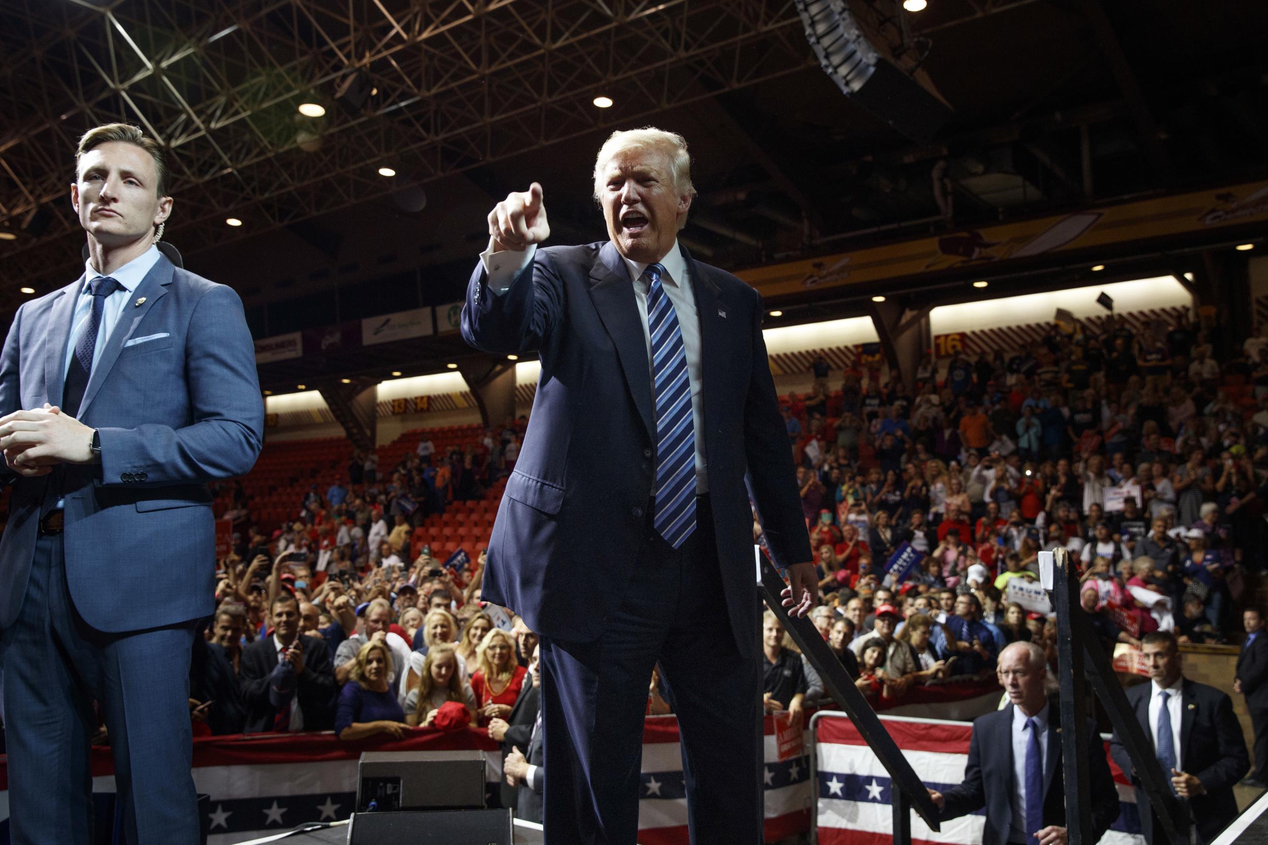 Republican presidential candidate Donald Trump points to the crowd during a rally