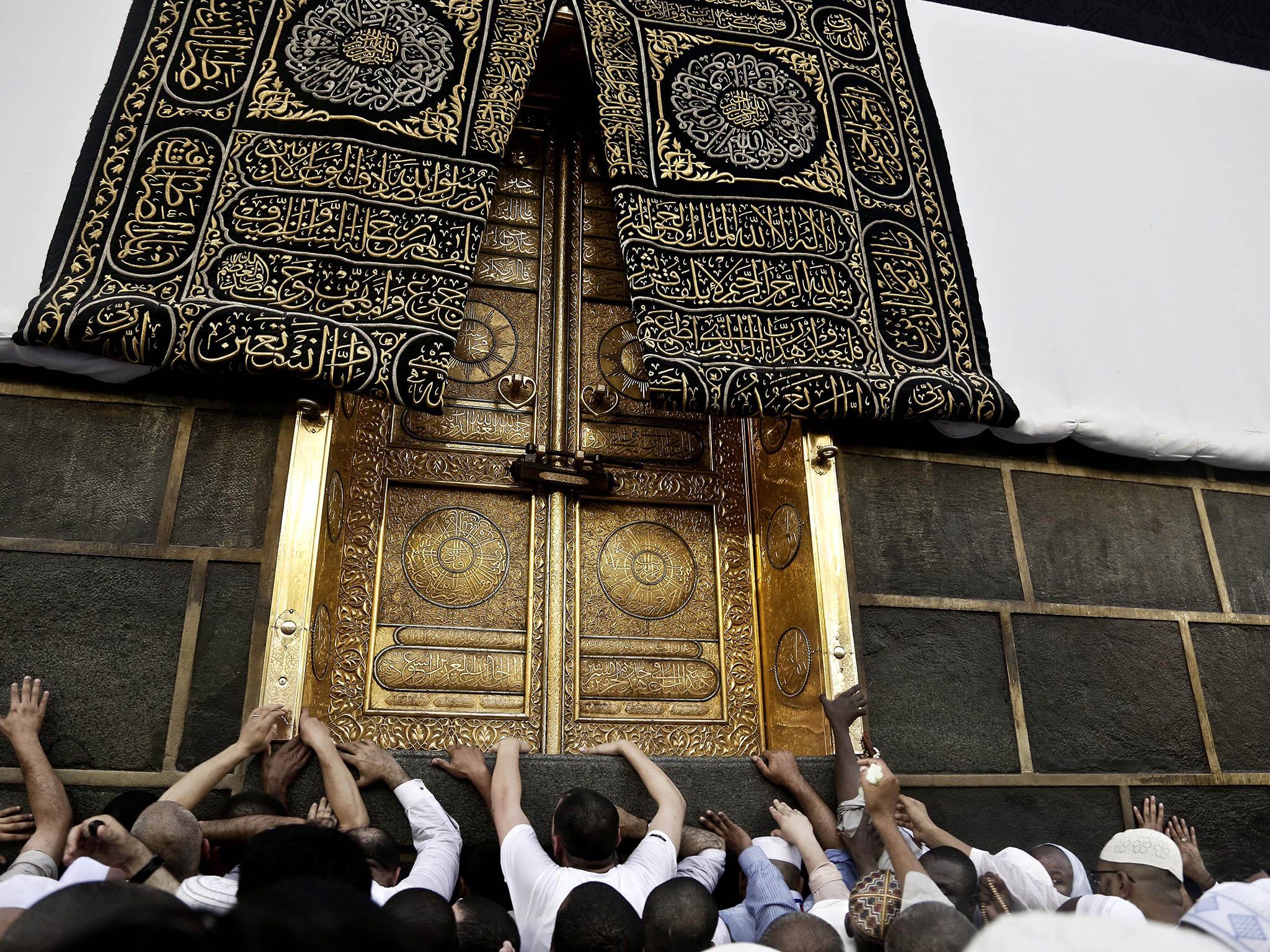 The golden door, which pilgrims are seen touching, is part of the holi shrine