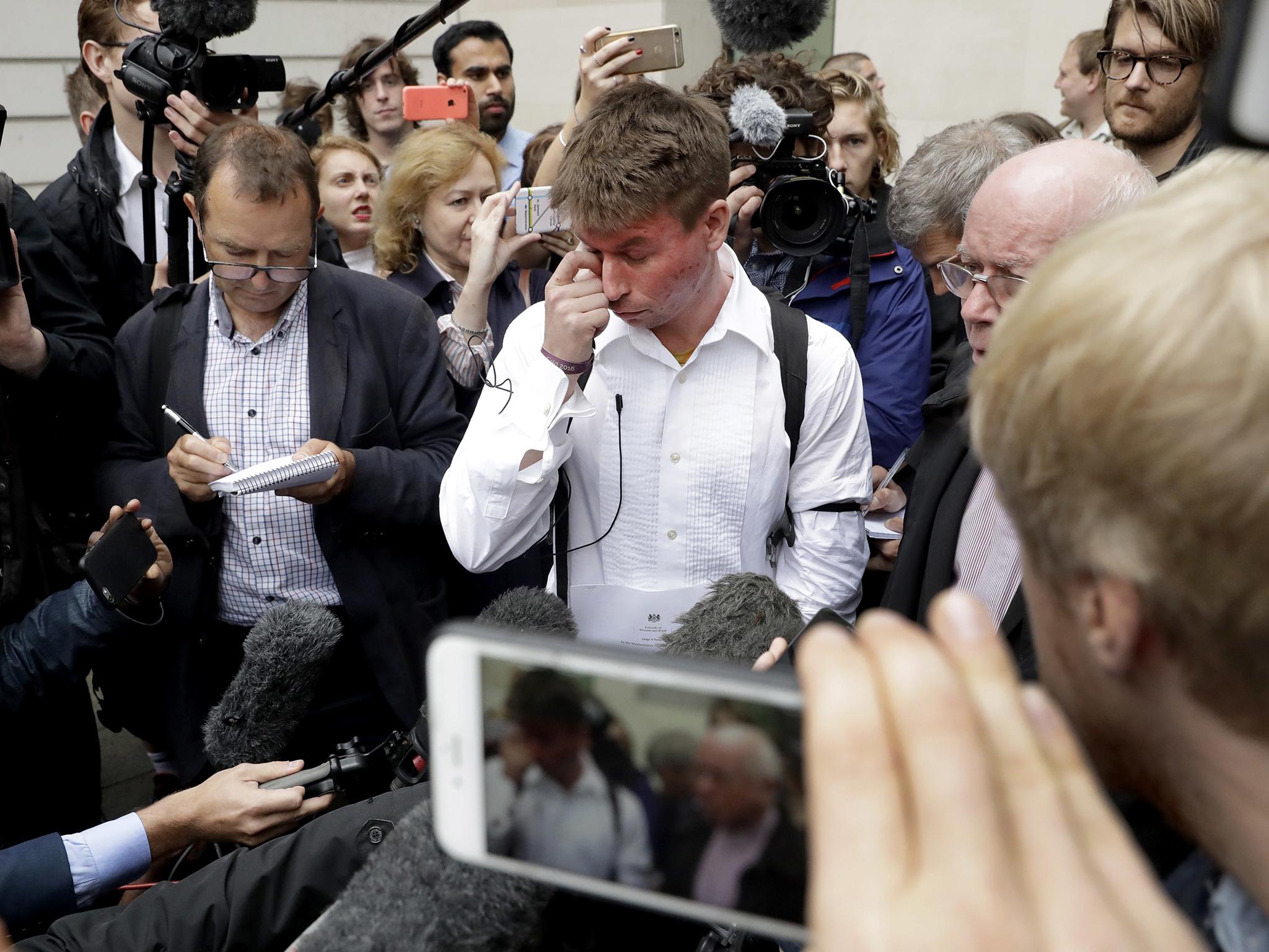 British national Lauri Love, who is accused of hacking into U.S. government computers, wipes away tears while speaking to the media after the ruling that he should be extradited, outside Westminster Magistrates' Court in London