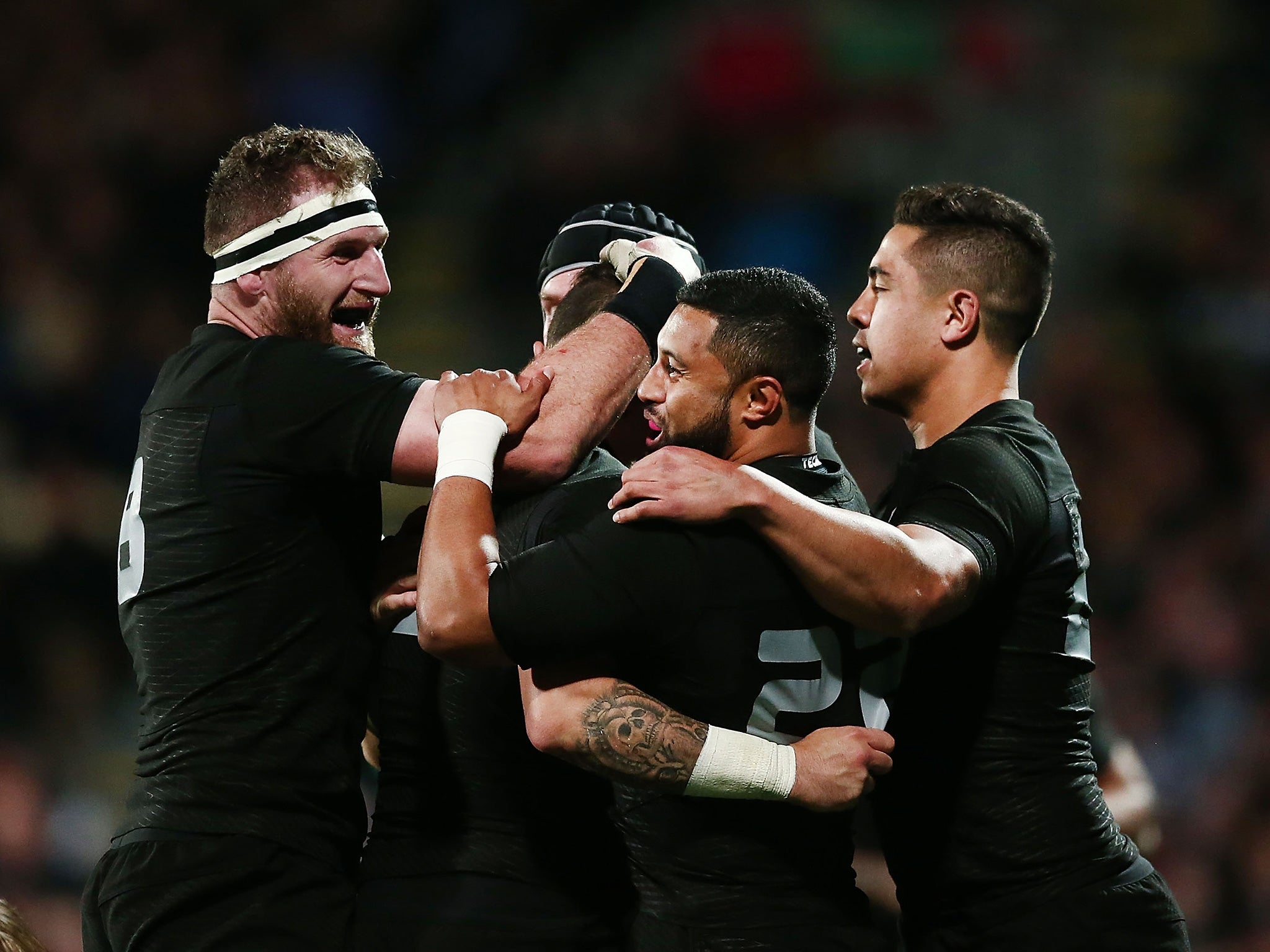 TJ Perenara is mobbed after crossing the line for the All Blacks