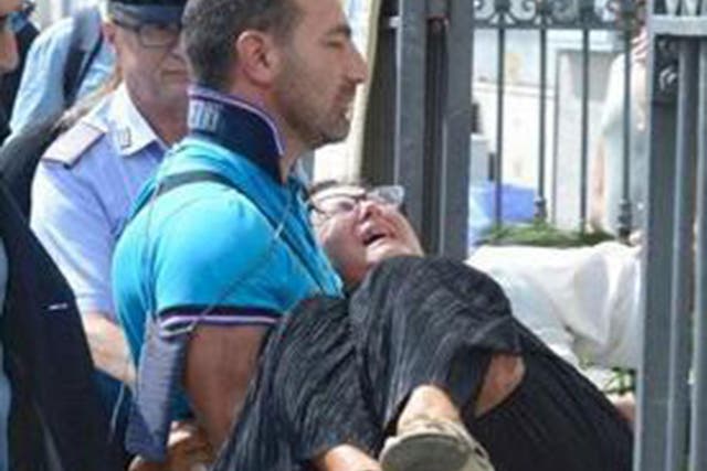 A man carries Teresa Giglio, the mother of Tiziana Cantone, into her daughter's funeral