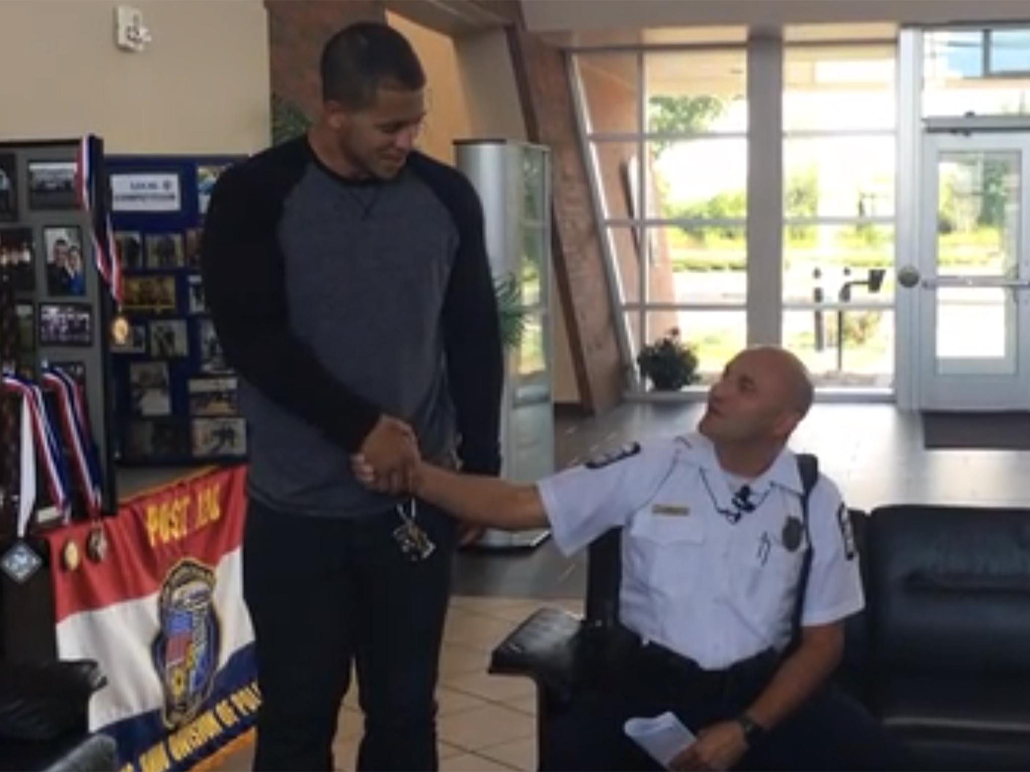 Christopher Jones (L) shakes Officer James Poole's (R) hand