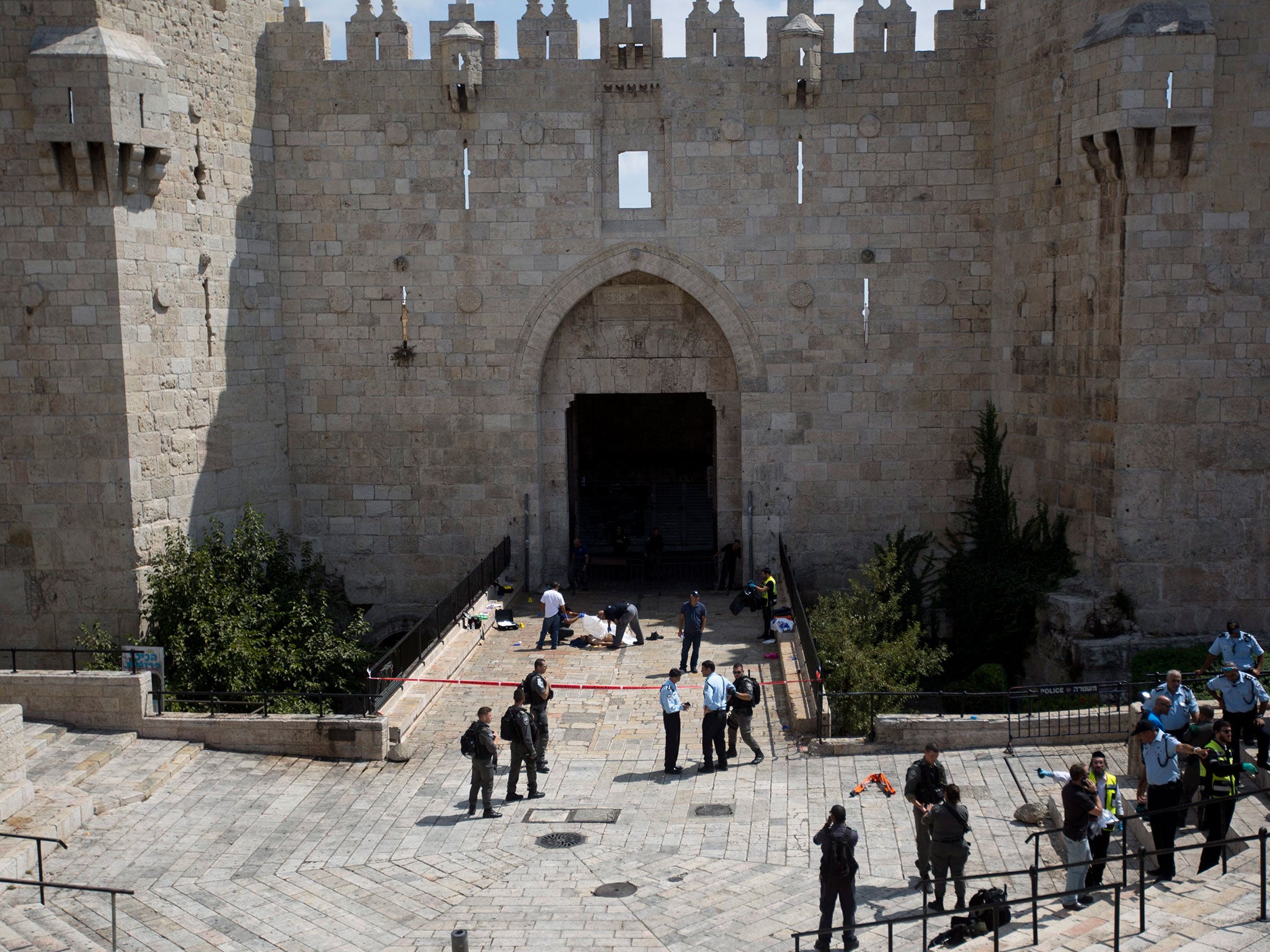 Israeli Border Police surround the body of a man shot while attempting to attack officers with a knife at Damascus Gate in East Jerusalem on 16 September