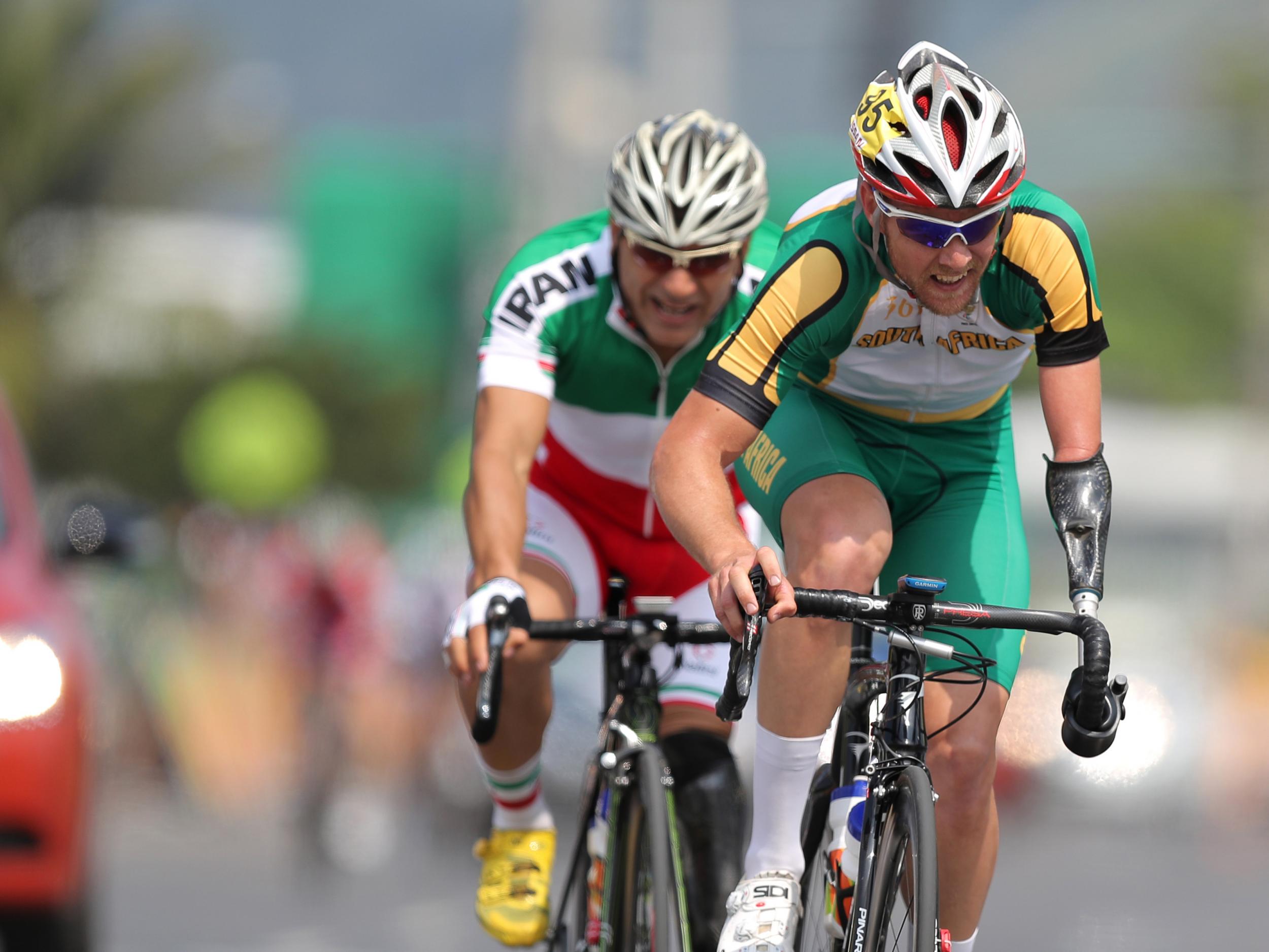 Iranian cyclist Bahman Golbarnezhad (L) behind South Africa's Dane Wilson (R) in the men's road race C4-5