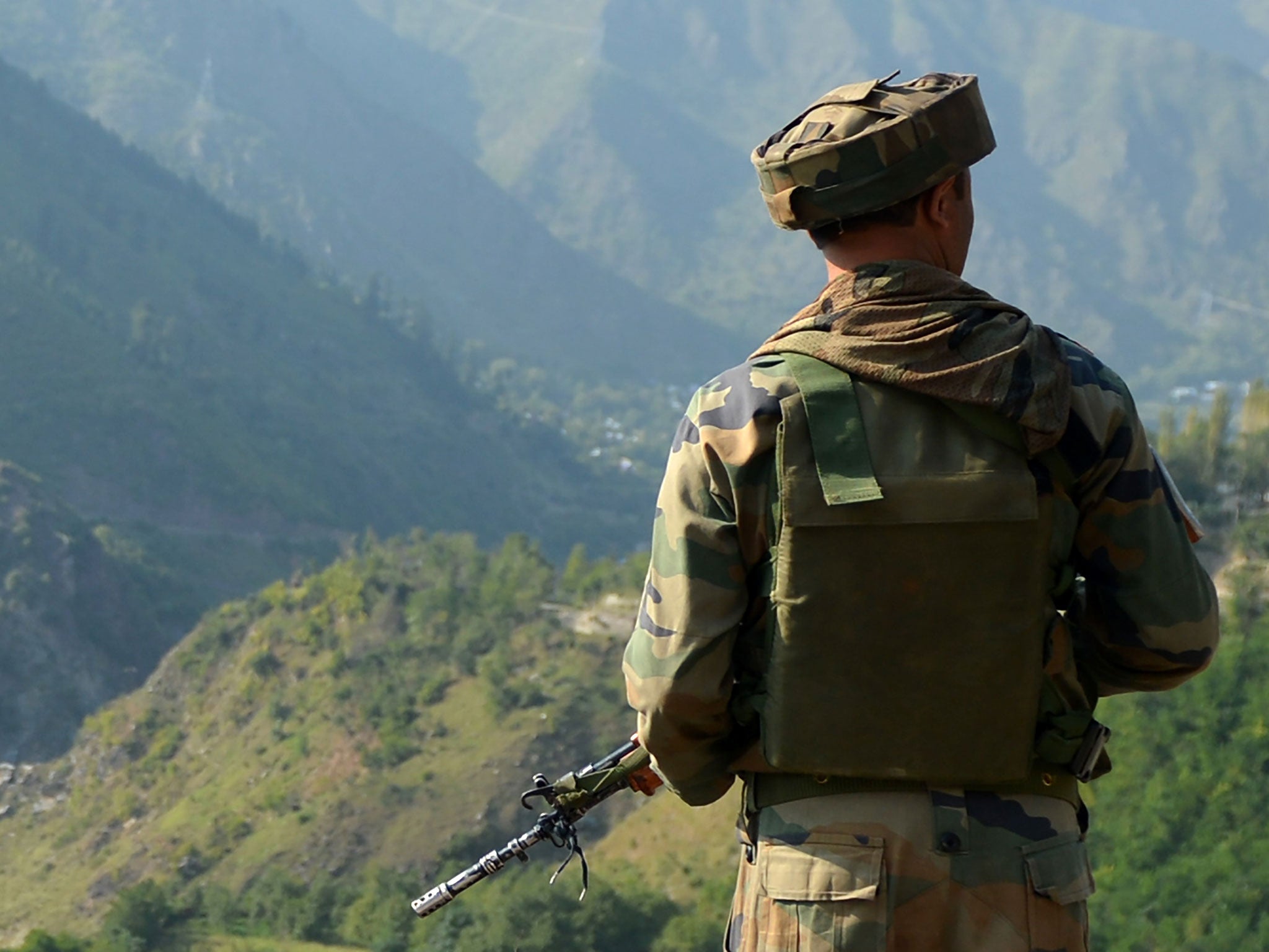 An Indian army soldier looks towards the site of a gunbattle between Indian army soldiers and rebels inside an army brigade headquarters near the border with Pakistan, known as the Line of Control (LoC), in Uri on September 18, 2016