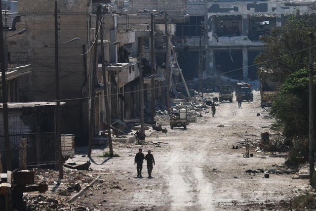  Syrian pro-regime fighters walk in a bombed-out steet in Ramussa, after they took control of the strategically important district on the outskirts of the Syrian city of Aleppo 