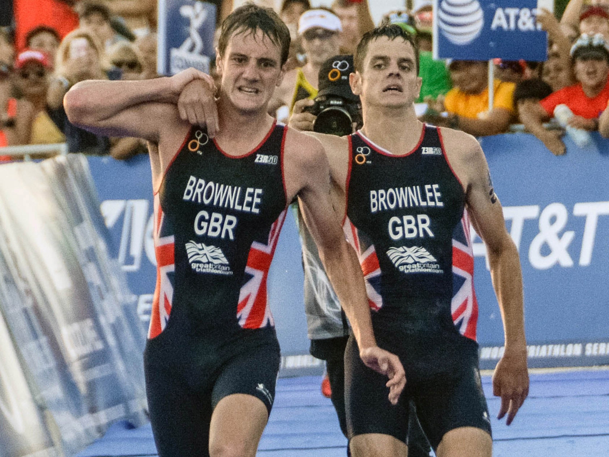 &#13;
Alistair Brownlee (left) helps his brother Jonny across the finish line &#13;