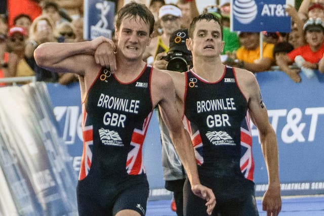Alistair Brownlee (left) helps his brother Jonny across the finish line