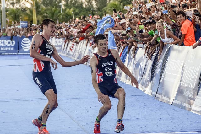 Jonny Brownlee collapses as he reaches the finish line alongside brother Alistair