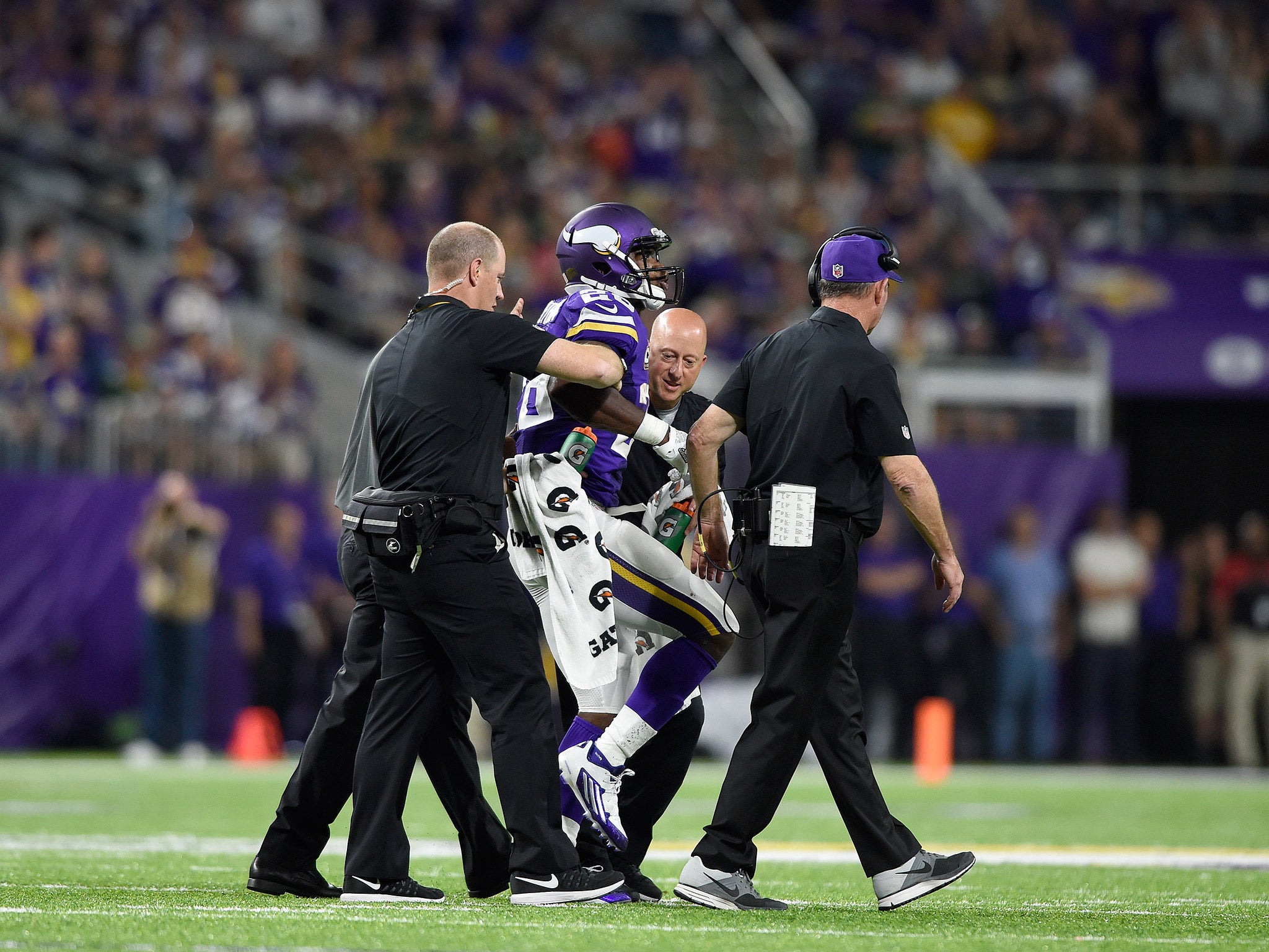 Adrian Peterson limps off the pitch with a knee injury