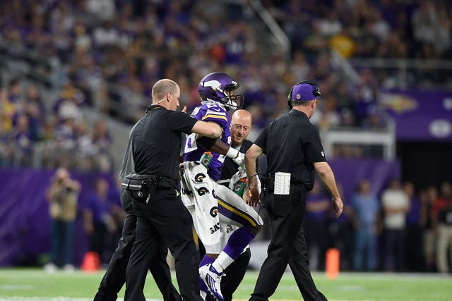 Adrian Peterson limps off the pitch with a knee injury
