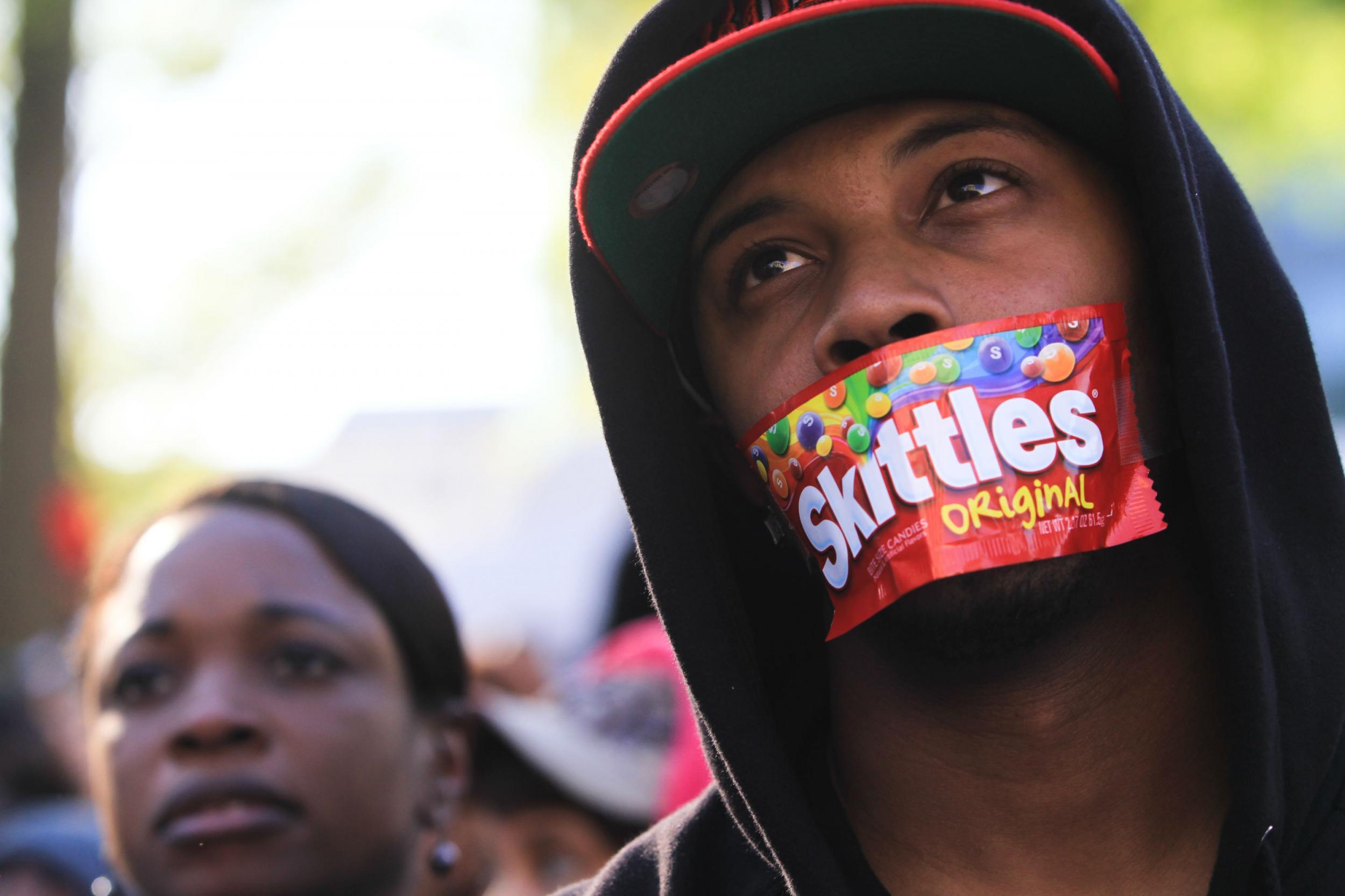 A protester plasters a packet over his mouth to express how Trayvon Martin was wrongfully killed