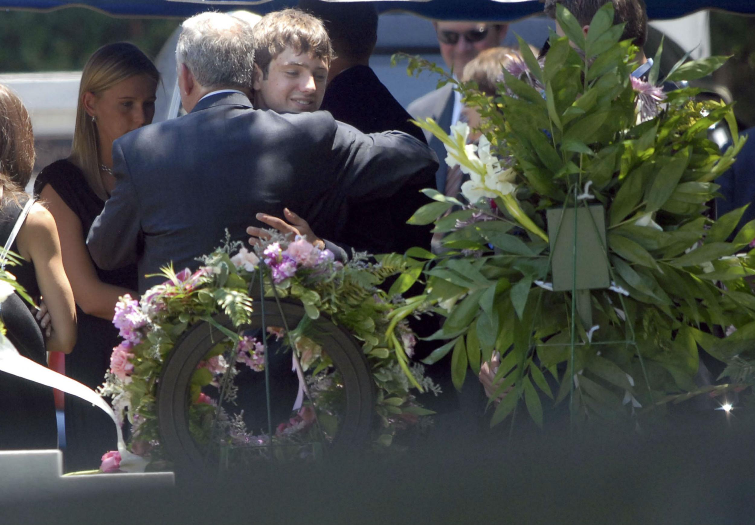Burke Ramsey hugs his father at his mother's funeral in 2006