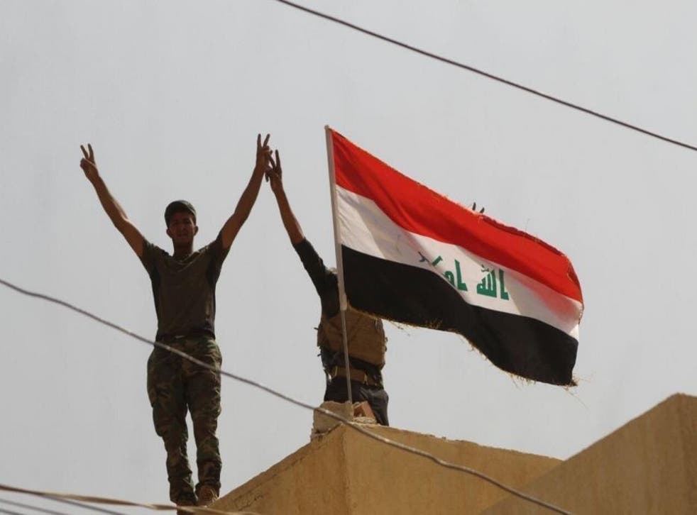 Soldiers stand on a roof in Shirqat having ousted Isis militants from the town