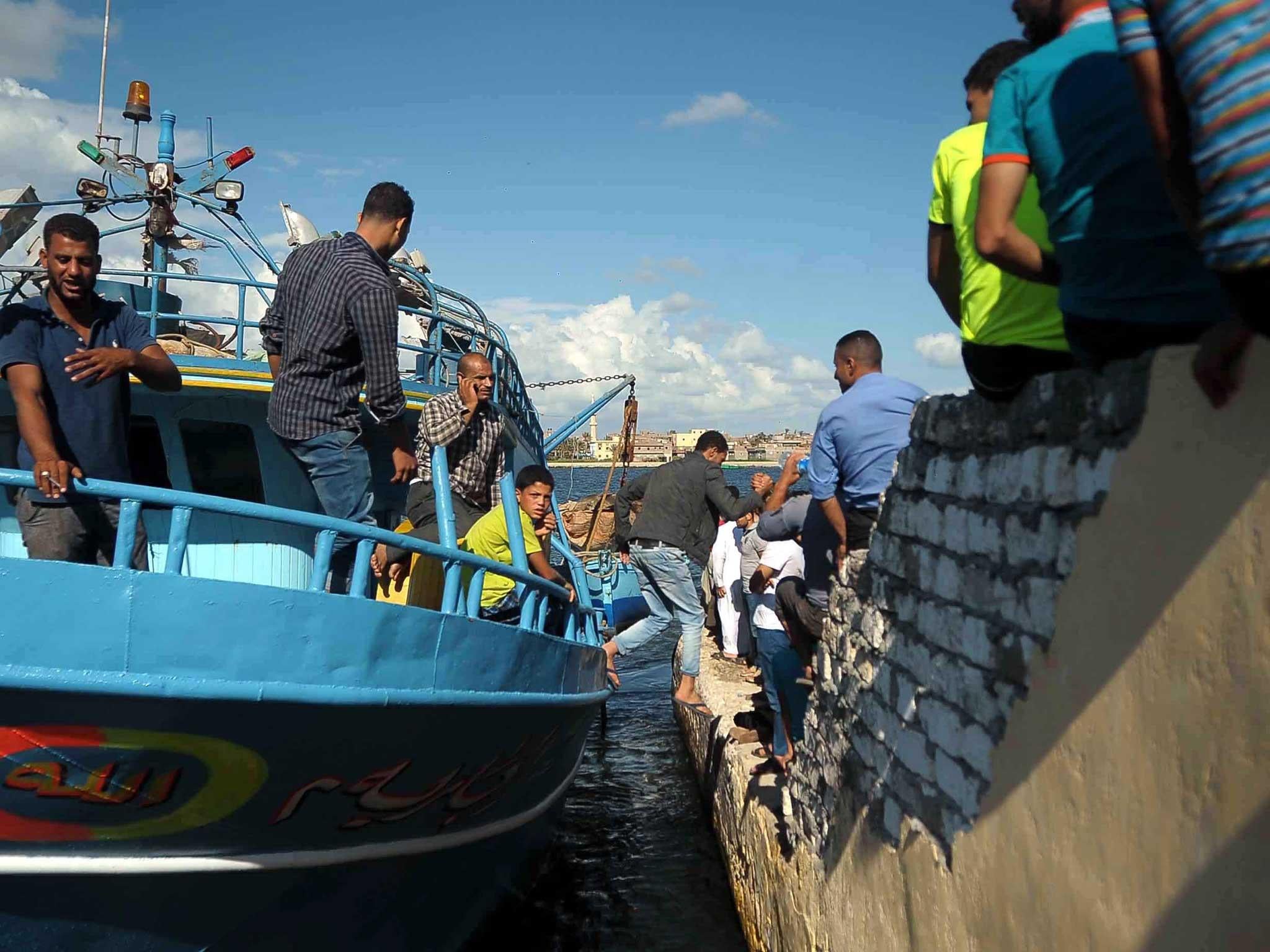 A boat carrying rescue teams returns to the shore at the port city of Rosetta, Egypt