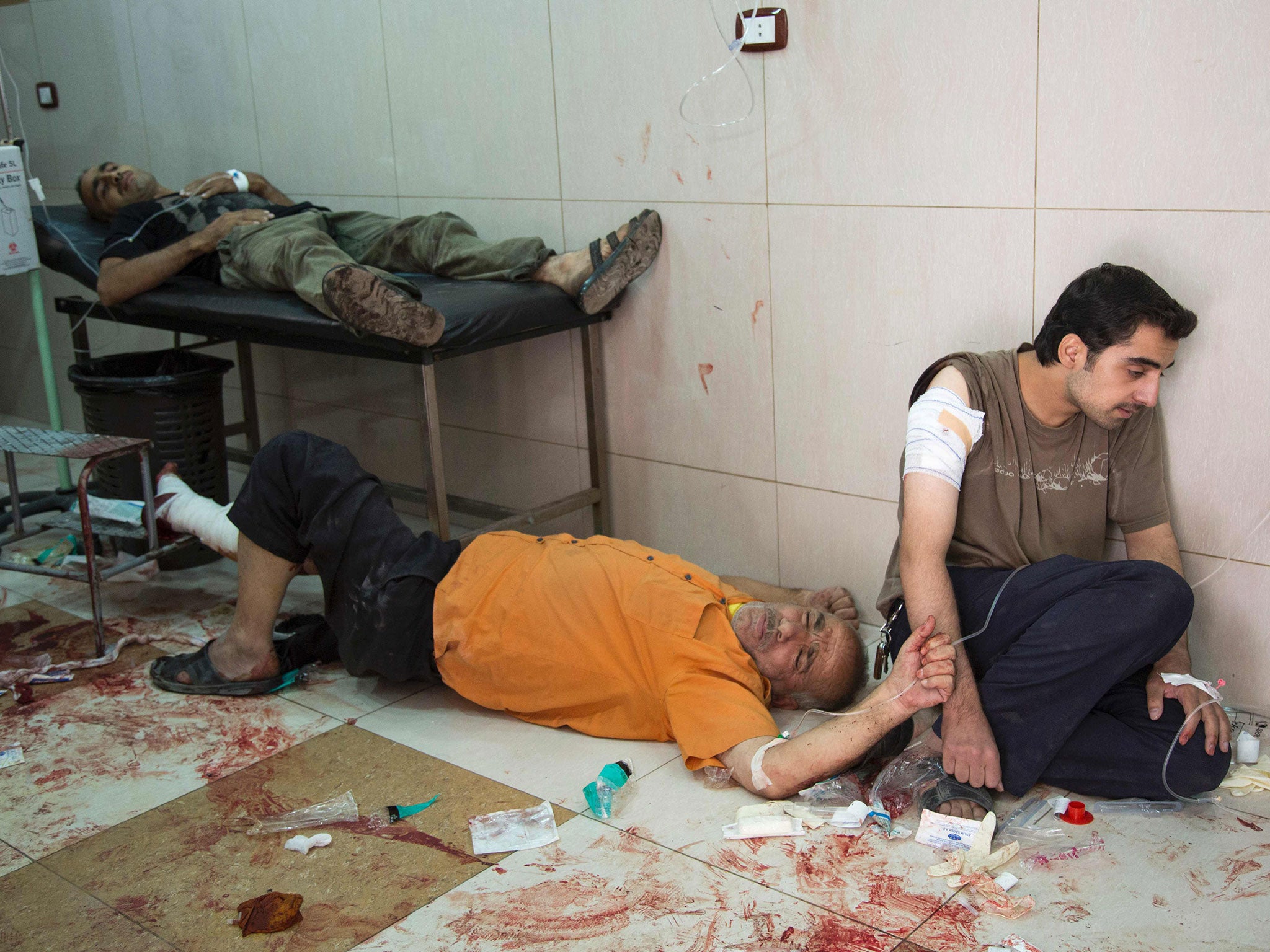 Syrians await to receive treatment at a makeshift hospital (Getty)