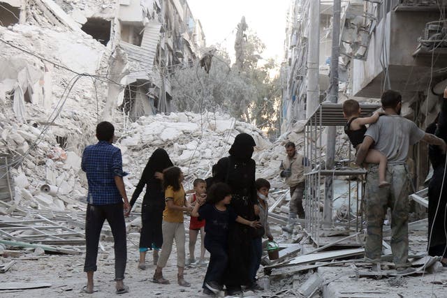 A Syrian family leaves the area following a reported air strike on September 23, 2016, on the al-Muasalat area in Aleppo.