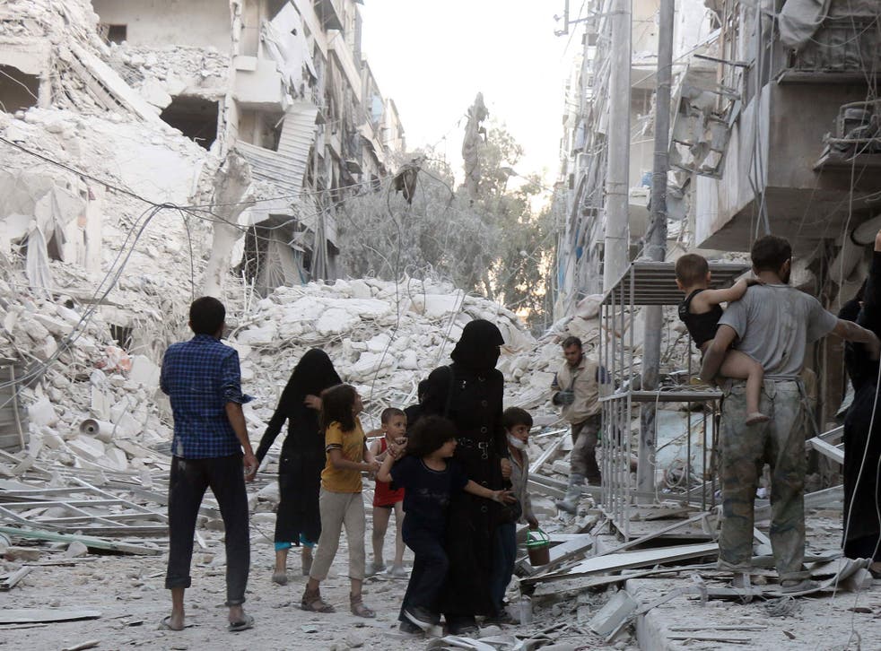 A Syrian family leaves the area following a reported air strike on September 23, 2016, on the al-Muasalat area in Aleppo.