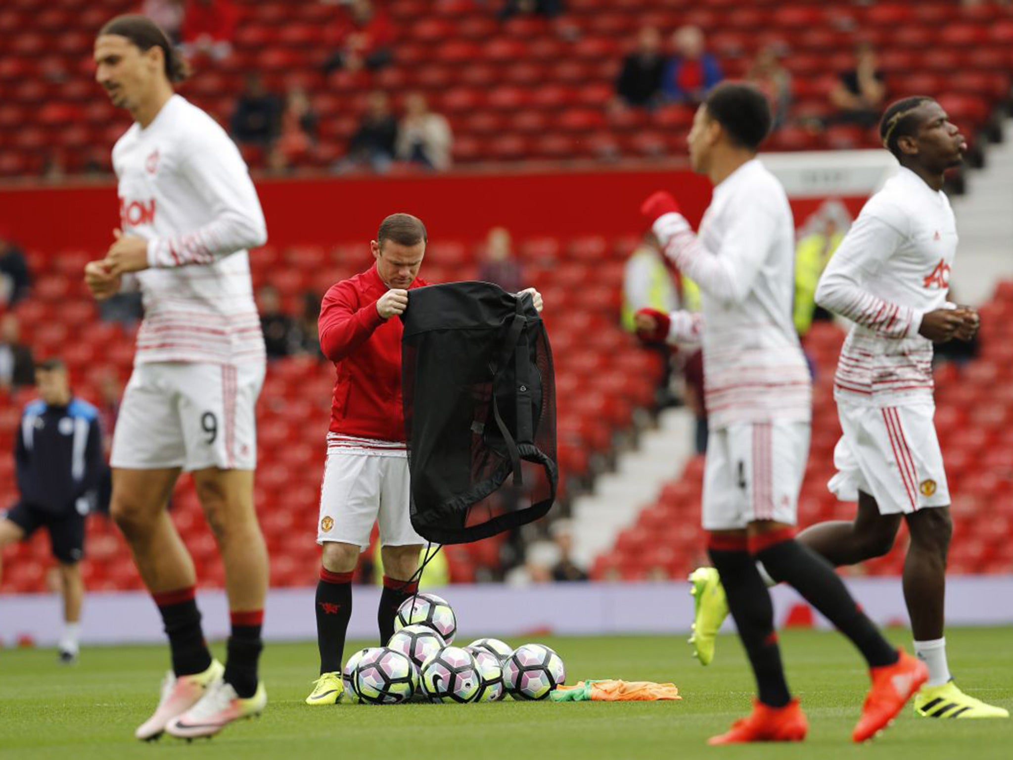 Rooney on ball bag duty as his team-mates warm up