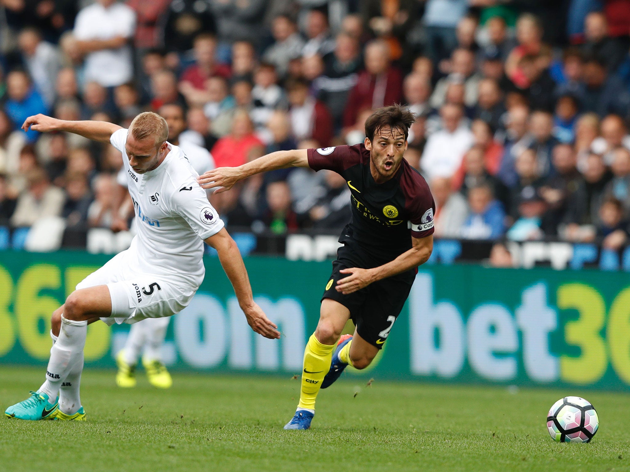 David Silva chases the ball past Swansea City's Mike van der Hoorn