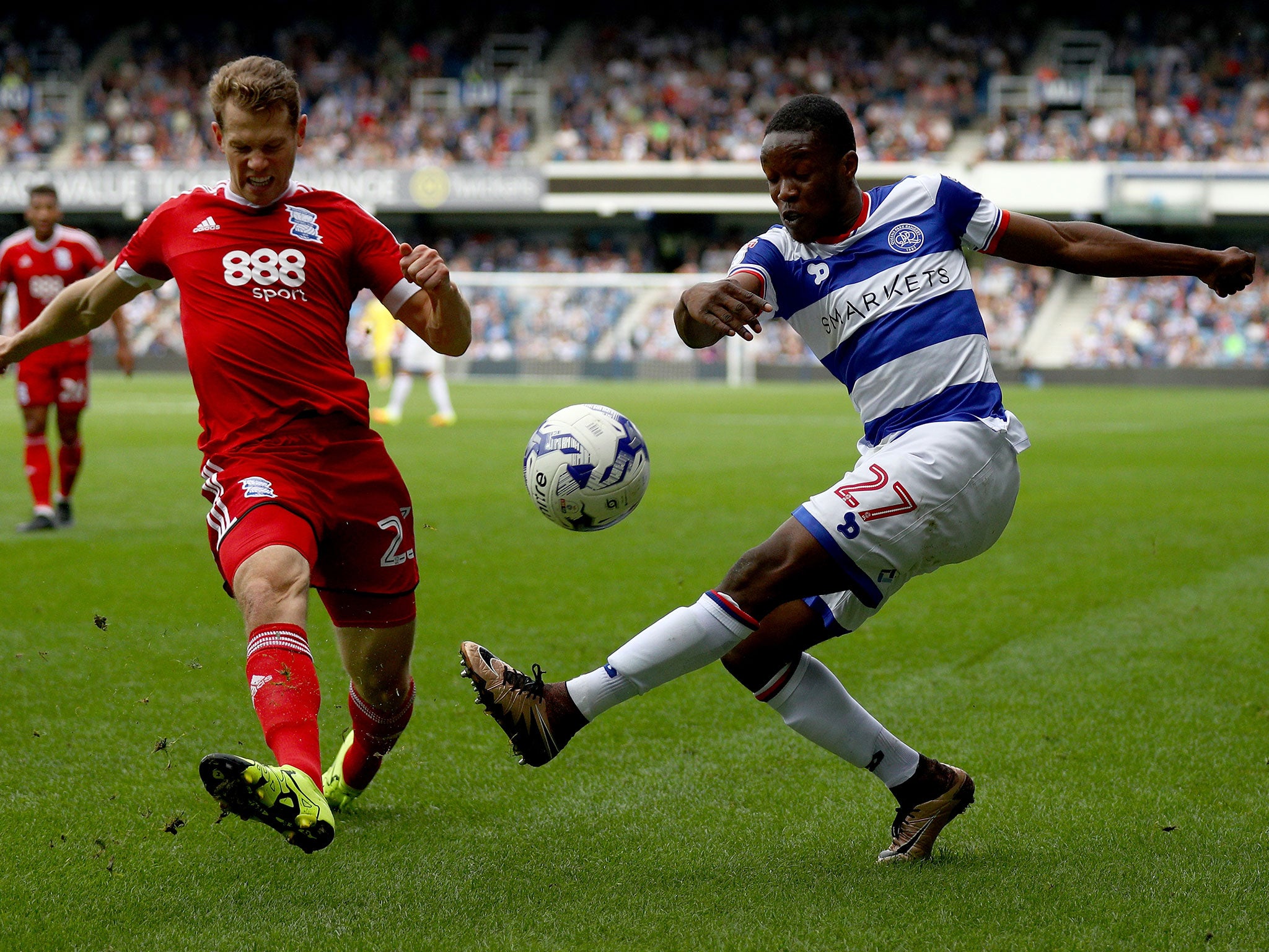 Jonathan Spector of Birmingham City tries to block a cross from QPR's Olamide Shodipo