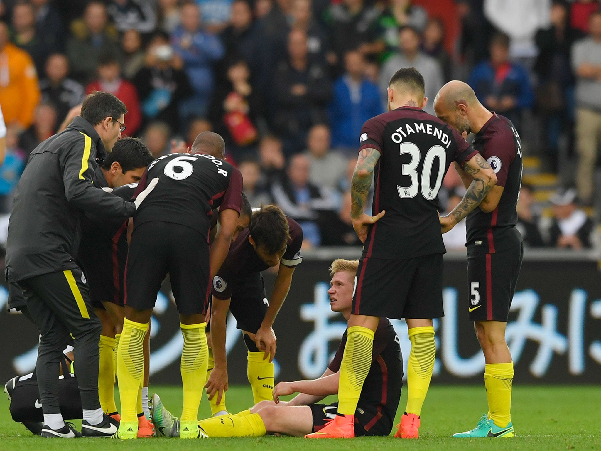 Kevin de Bruyne is attended to by players and City's medical staff