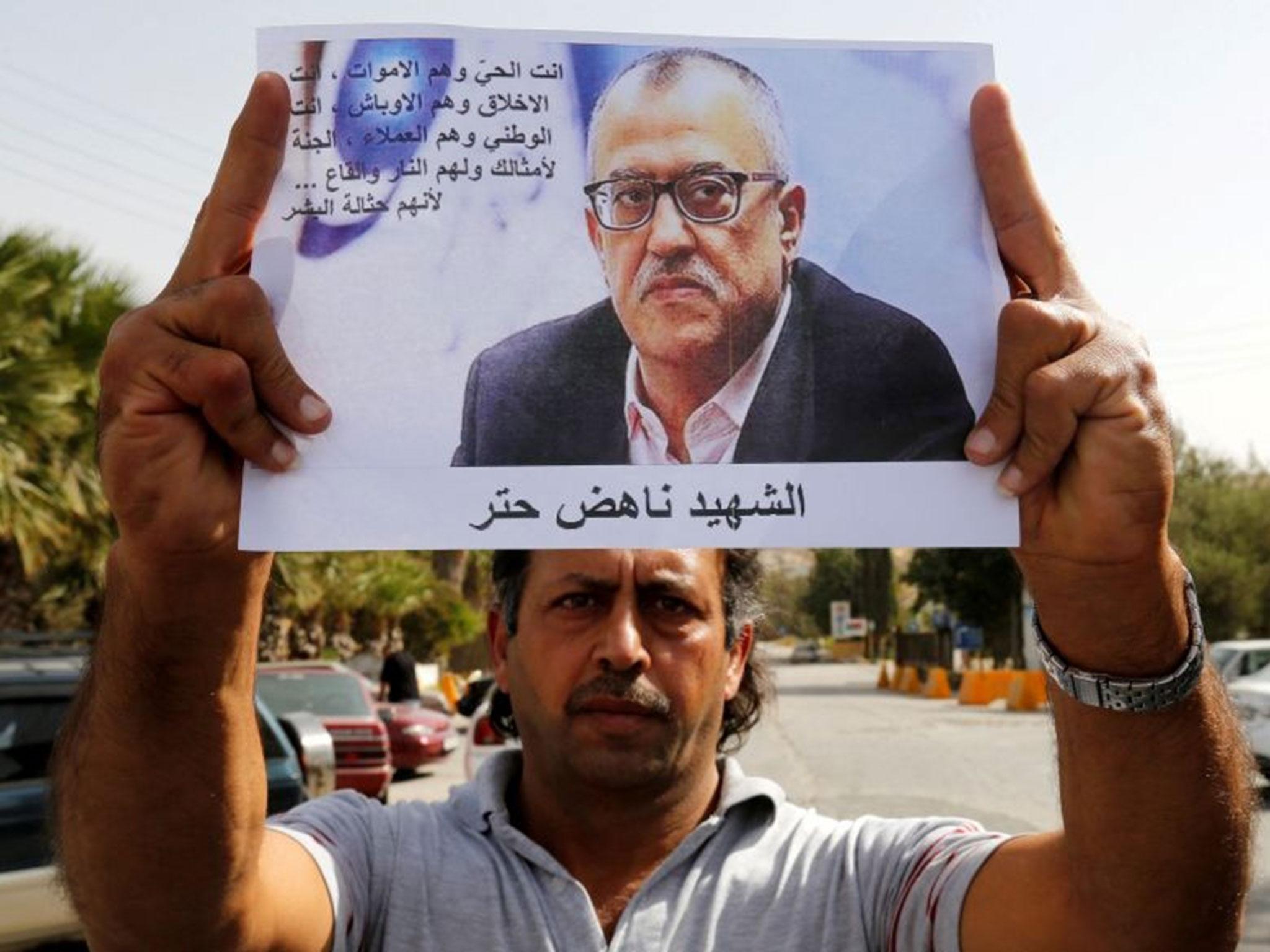 A relative of Jordanian writer Nahed Hattar holds his picture during a sit-in in the town of Al-Fuheis near Amman, Jordan, 25 September, 2016