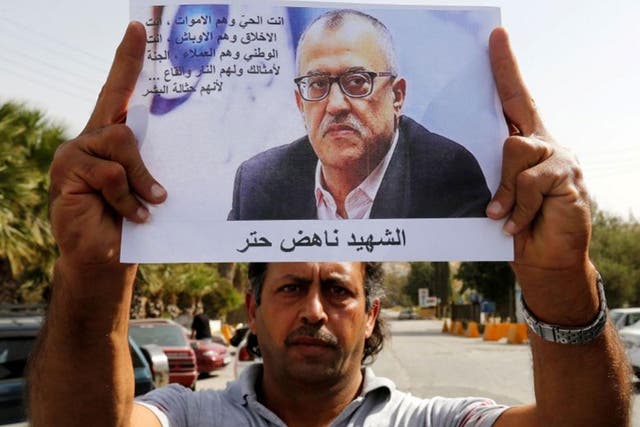 A relative of Jordanian writer Nahed Hattar holds his picture during a sit-in in the town of Al-Fuheis near Amman, Jordan, 25 September, 2016