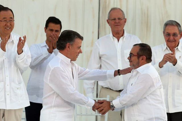 The Colombian President Juan Manuel Santos (left) and the top commander of the Revolutionary Armed Forces of Colombia (FARC) Rodrigo Londono, shake hands after signing the peace agreement yesterday