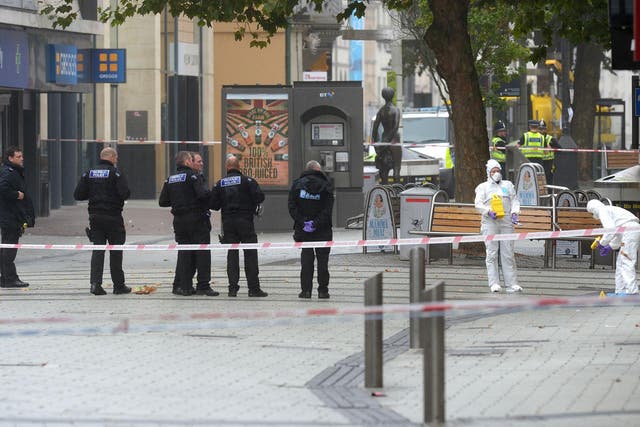 Police and forensics officers at the scene in Queen Street, near Cardiff Castle after the bodies of a man and a woman were found in Cardiff city centre