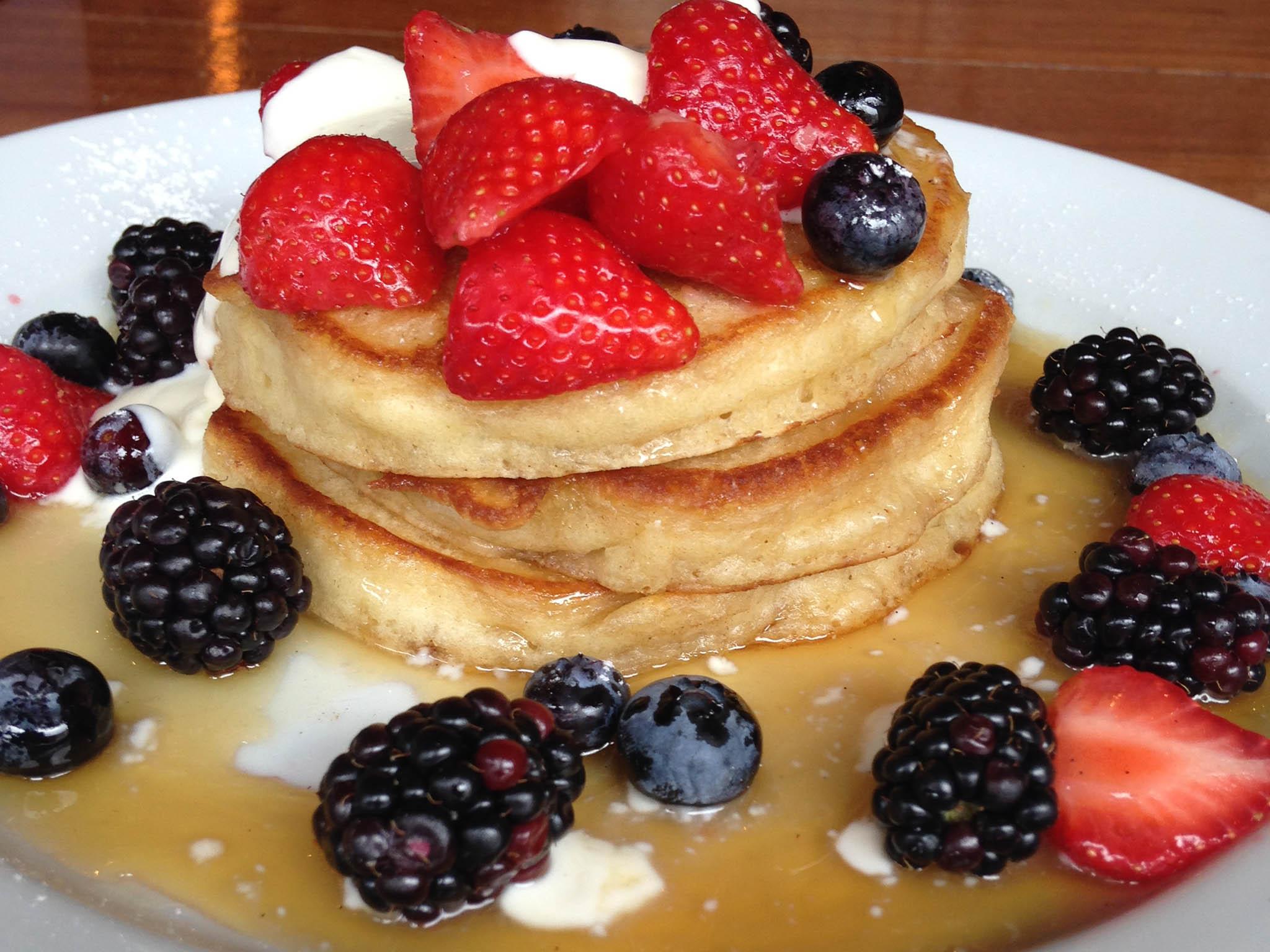 American pancakes covered in strawberries, blackberries and blueberries