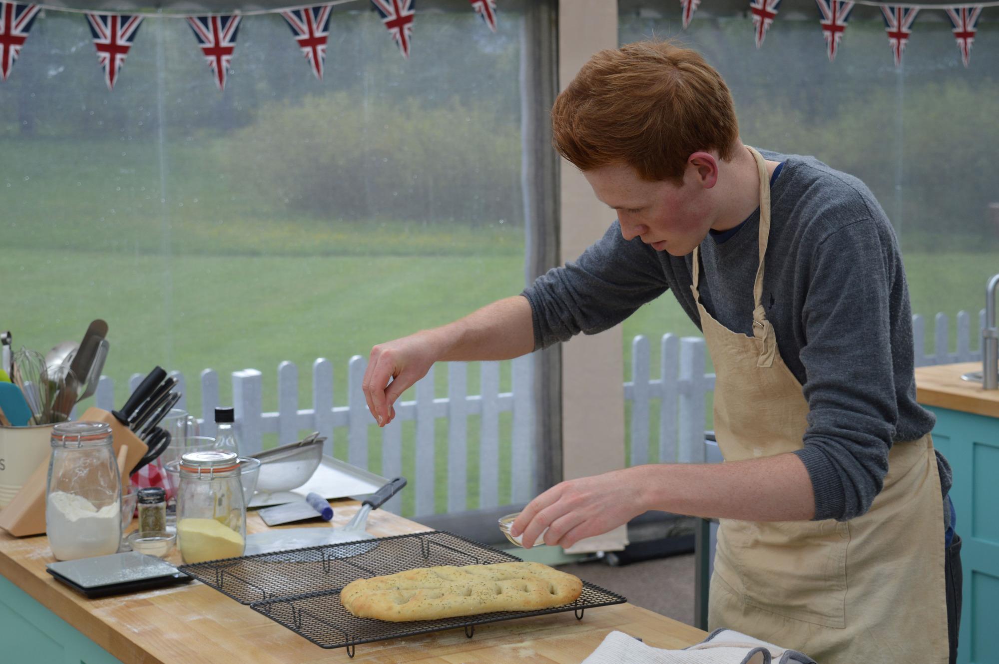 Andrew adds a sprinkle of salt to his herby bread during the technical challenge (BBC)