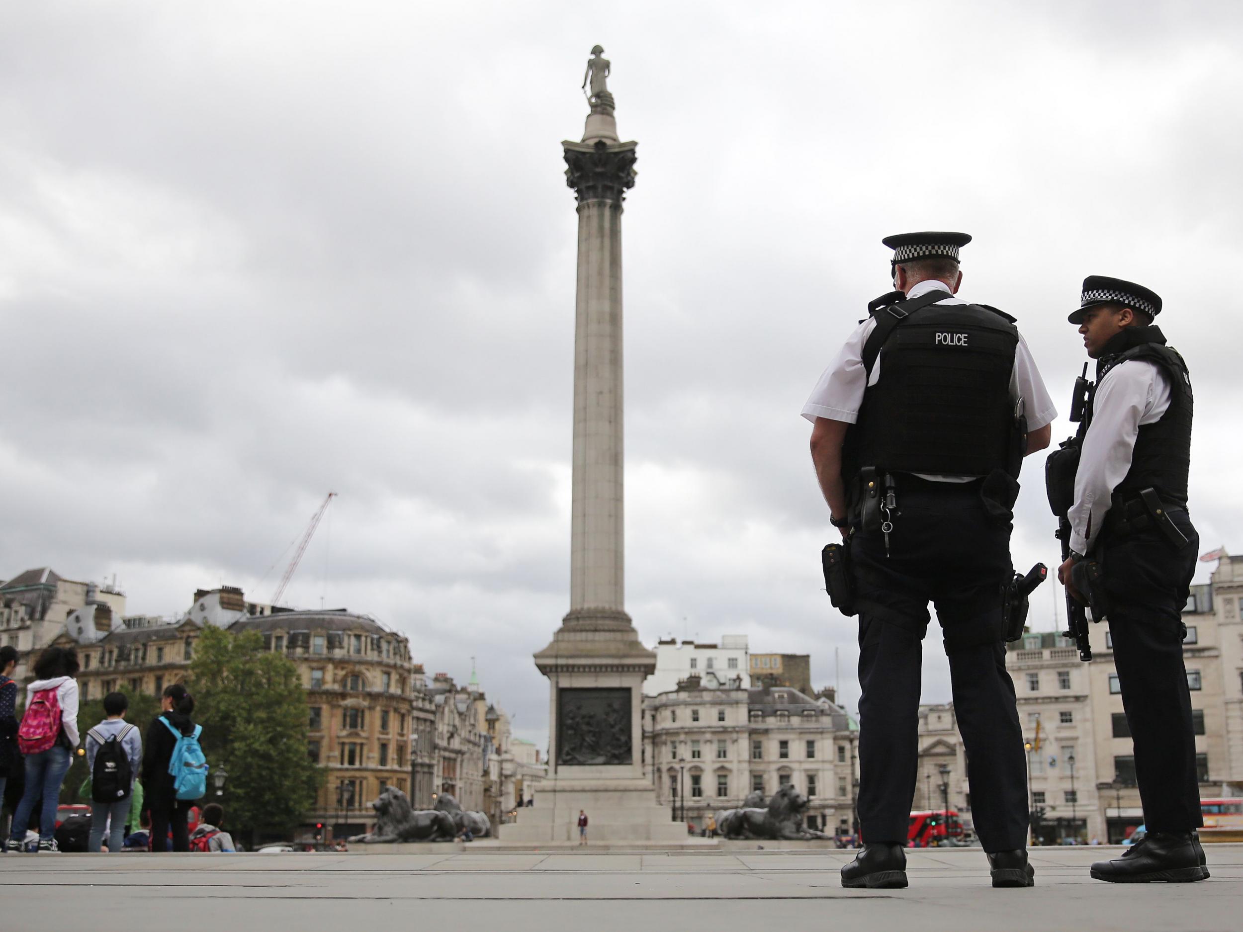 Armed police personnel patrol in London's Trafalgar Square in August