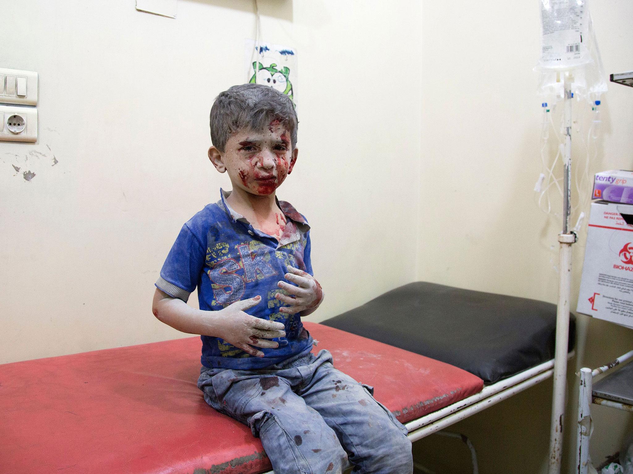 A Syrian boy awaits treatment at a make-shift hospital following air strikes on rebel-held eastern areas of Aleppo on 24 September, 2016