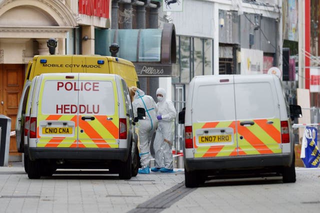 Forensic officers at the scene in Queen Street, near Cardiff Castle after the bodies of a man and a woman were found in Cardiff city centre