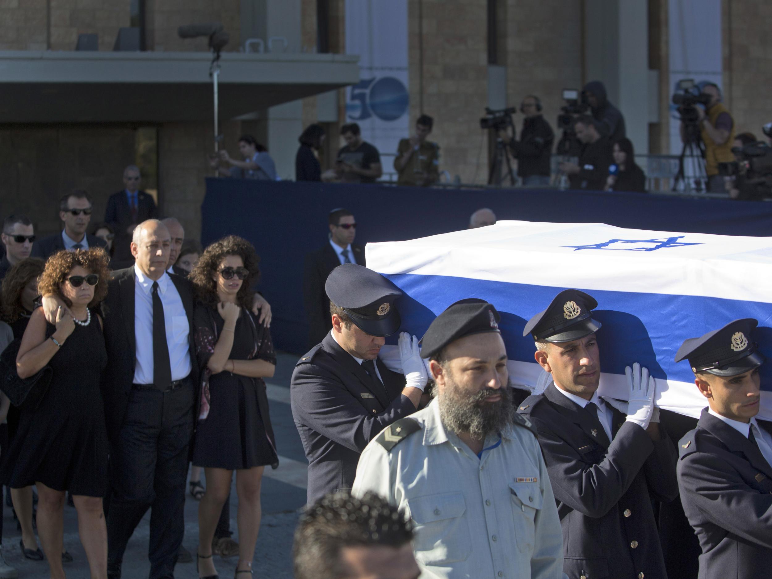 Family members follow as members of the Knesset guard carry the coffin of former Israeli President Shimon Peres