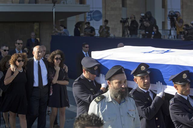 Family members follow as members of the Knesset guard carry the coffin of former Israeli President Shimon Peres