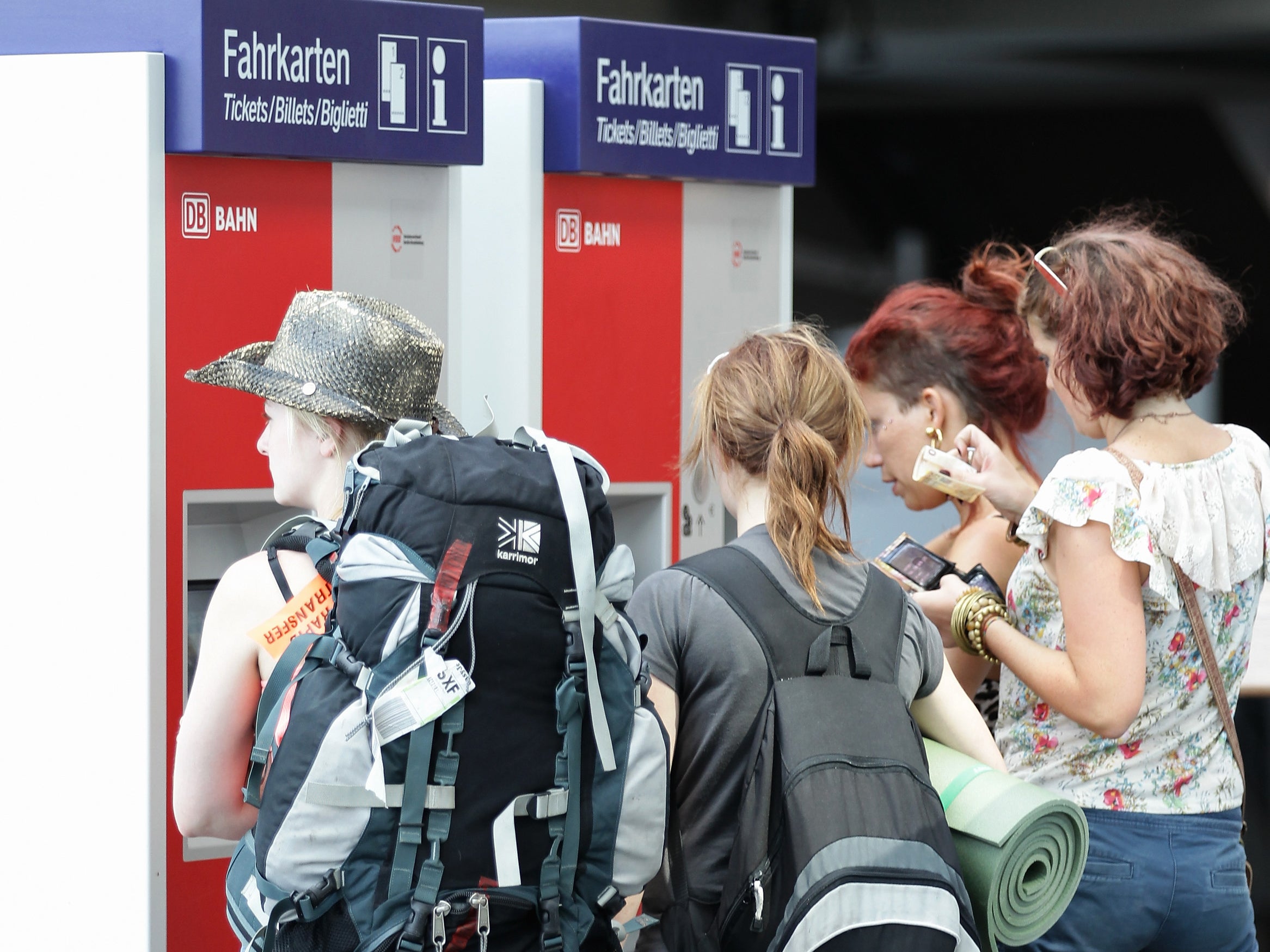 Backpackers queue up at a ticket machine at Hauptbahnhof train station in Berlin, Germany