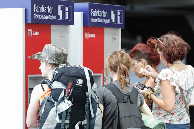 Backpackers queue up at a ticket machine at Hauptbahnhof train station in Berlin, Germany