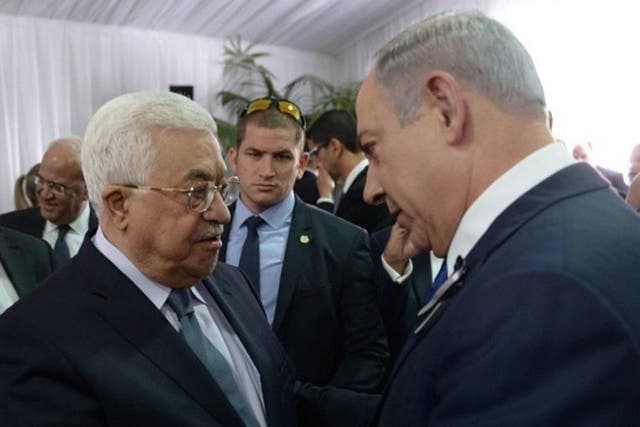 In this handout photo by the Israel Government Press Office (GPO), Israeli Prime Minister Benjamin Netanyahu shakes hands with Palestinian Authority President Mahmoud Abbas