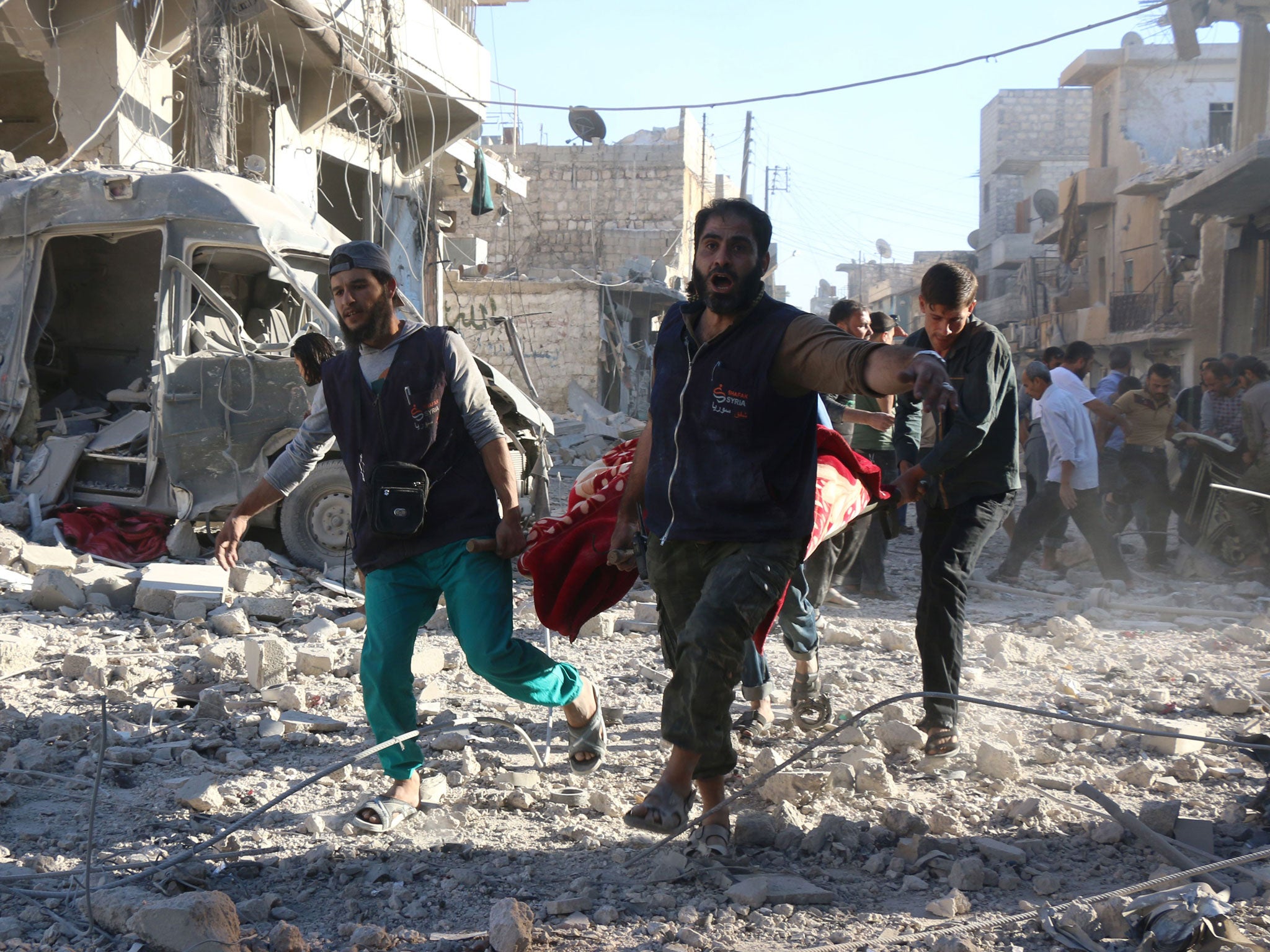 Syrian volunteers carry an injured person on a stretcher following suspected Syrian government forces air strikes on the rebel held neighbourhood of Heluk in Aleppo